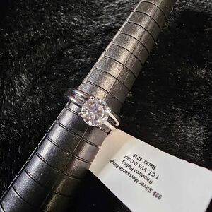 1.0CTW VVSD Moissanite Solitaire set in Rhodium over 925 Sterling Silver. Size 5